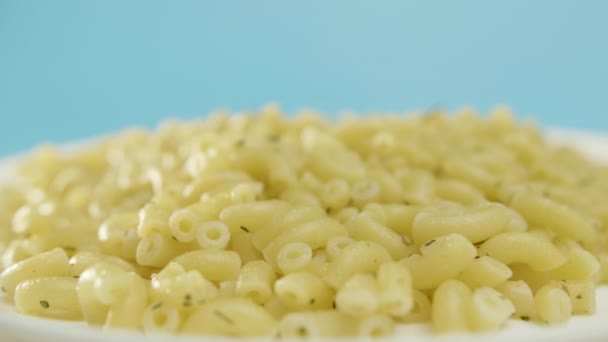 Pasta corna ruota sul tavolo su sfondo blu — Video Stock