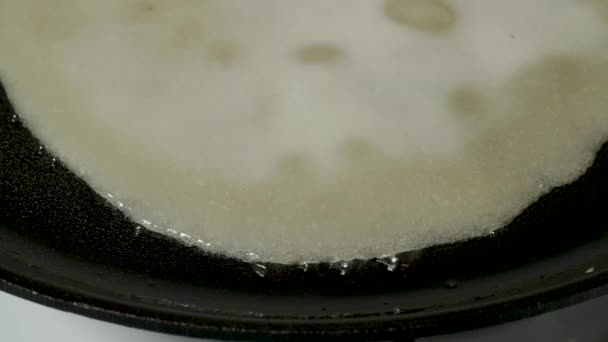 Делать жареные блины в чугунной сковородке вид сверху — стоковое видео