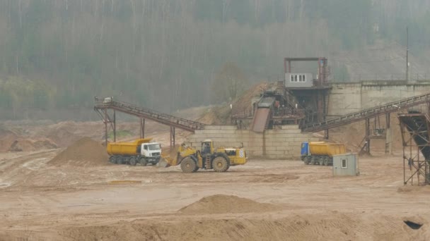 Camiones máquina funciona en la cantera de lastre de arena en el día nublado de verano — Vídeo de stock