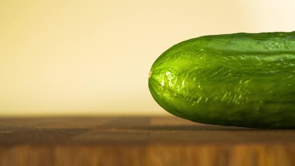 Komkommer aan het hakken. Sluiten van gesneden groente op houten snijplank. Stop bewegingsanimatie — Stockvideo