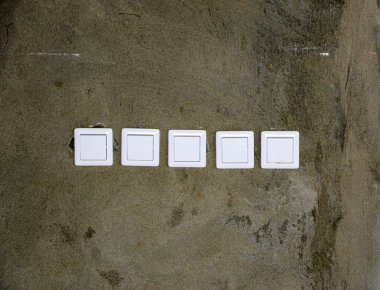 Elektrik prizleri ve anahtarlar tamir sırasında apartman veya ofis odasının duvarında beyaz plastikten yapılmış..