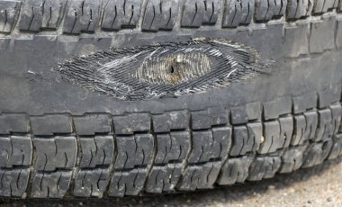 Kamyonun sürtünme tekerleği. Lastikte delik olan yıpranmış tekerlek, kordona lastik izi.