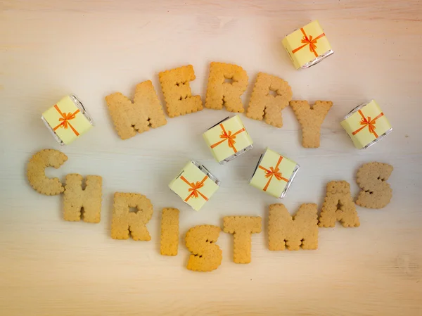 Czekoladowe prezenty i herbatniki wykonane napis "Wesołych Świąt". Stonowanych obrazów. — Zdjęcie stockowe