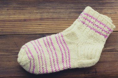 El yapımı rustik ahşap zemin üzerine yün çocuk çorap örme.