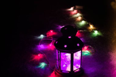 Tatil tebrik kartı veya arka plan. Noel ışıkları ve mum fener koyu arka plan üzerinde. Noel evde. Yeni yıl tatil şablonu.