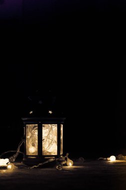 Tatil tebrik kartı veya arka plan. Noel ışıkları ve mum fener koyu arka plan üzerinde. Noel evde. Yeni yıl tatil şablonu.