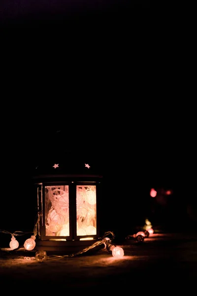 Вітальна листівка або тло. Різдвяні вогні та свічковий ліхтар на темному тлі. Різдво вдома. Новорічний святковий шаблон . — стокове фото