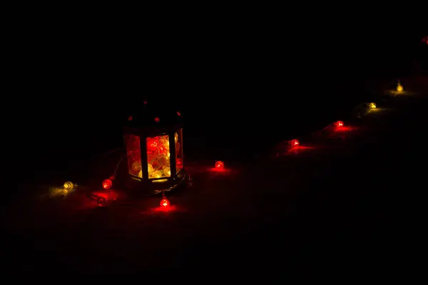Urlaubsgrußkarte oder Hintergrund. Weihnachtsbeleuchtung und Kerzenlaterne auf dunklem Hintergrund. Weihnachten zu Hause. Vorlage für das neue Jahr Urlaub. — Stockfoto