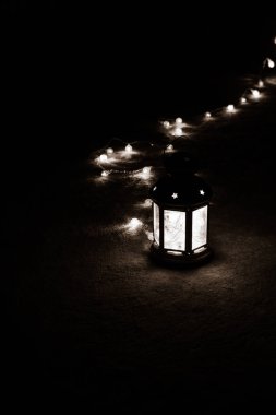 Tatil tebrik kartı veya arka plan. Noel ışıkları ve mum fener koyu arka plan üzerinde. Noel evde. Yeni yıl tatil şablonu.