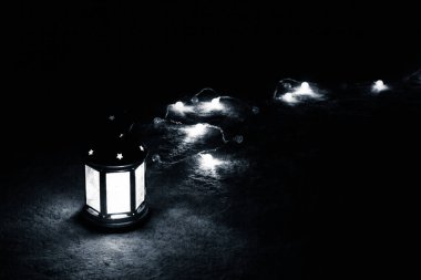 Tatil tebrik kartı veya arka plan. Noel ışıkları ve mum fener koyu arka plan üzerinde. Noel evde. Yeni yıl tatil şablonu.