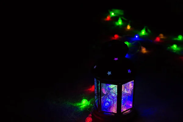 Tarjeta de felicitación de vacaciones o fondo. Luces navideñas y linterna de vela sobre fondo oscuro. Navidad en casa. Plantilla de vacaciones de año nuevo . — Foto de Stock