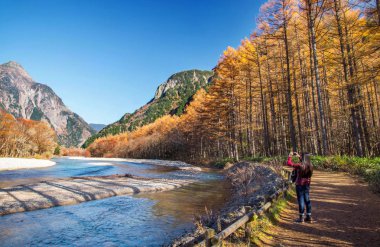 Matsumoto, Nagano, Japonya - Kasım 7,2016. Bir turist renkli sonbahar manzara Kamikochi Milli Parkı'nda fotoğraf çekici cep telefonu kullanmak