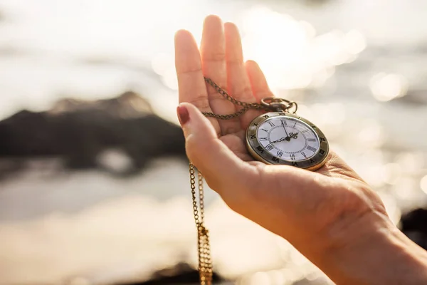Жінка тримає старовинний кишеньковий годинник — стокове фото