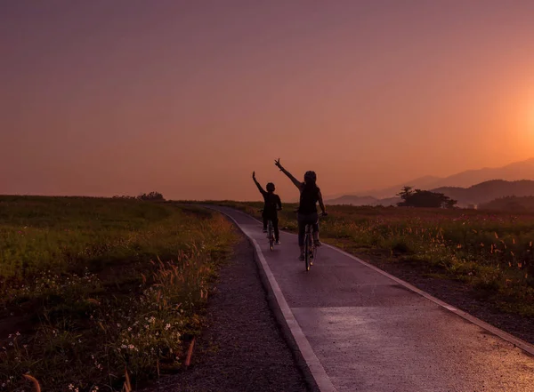 Силует друга на велосипеді під час сходу сонця — стокове фото