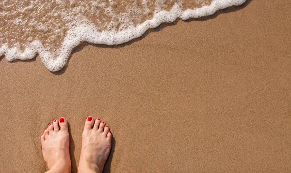 女性的脚站在夏季用沙的海滩上 — 图库照片