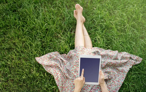 Жінка розслабляється і використовує планшет влітку, вид зверху — стокове фото