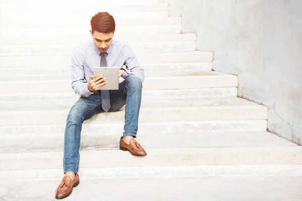 Empresario relajándose con tableta digital en la escalera — Foto de Stock