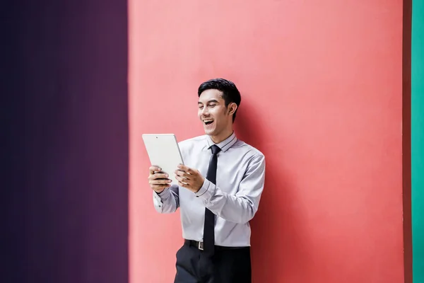Χαρούμενος νεαρός επιχειρηματίας να χαμογελάσει και να γελάσει με ψηφιακό tablet σε c — Φωτογραφία Αρχείου