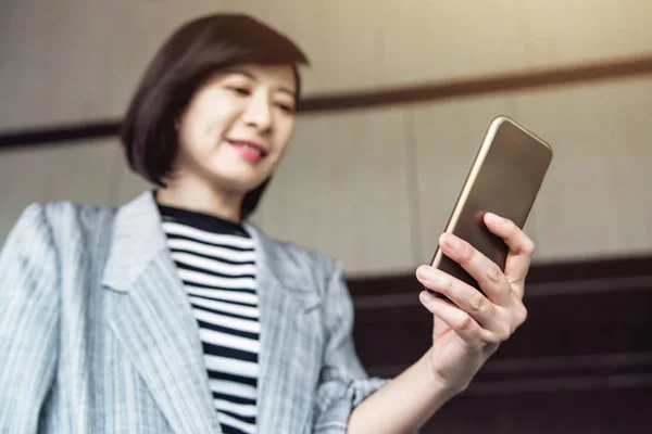 Mulher trabalhadora asiática feliz usar telefone inteligente — Fotografia de Stock