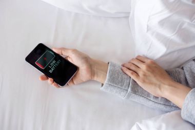 Akıllı telefon bağımlısı ve sağlıklı yaşam konsepti, el, aşırı vücut kadın uyku yatakta, cep telefonu tutarken düşük pil ve şarj veya dinlenme gerekir