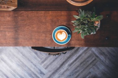 Dekorasyon ve iç tasarım kahve dükkanı, ahşap masa üzerinde sıcak Latte Lay fincan için üstten görünüm