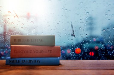 Hayat ve yaşam pozitif kavram, yağmurlu günde evde, bulanık ışık dış görünümü olarak şehirde kitap okumak