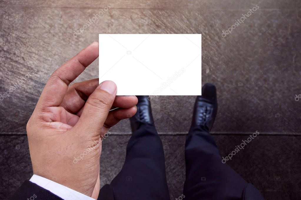 Business Card Mockup in Businessman Hand, White Paper Isolated with Clipping Path, Top View, Blank space for logo identity or text copy, Cement concrete floor as background