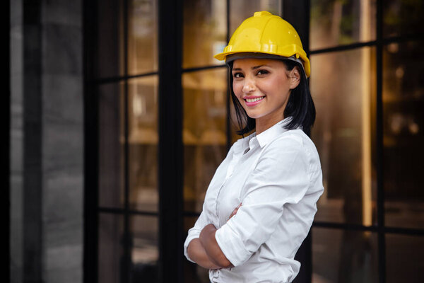 Portrait of a Confident Construction Engineer Woman. Smiling and Looking at Camera. Standing in front of the Modern Office Building