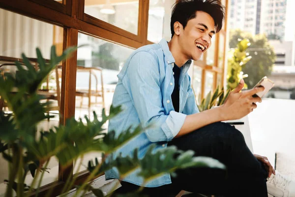 Happy Young Man Casual Wear Using Mobile Phone While Sitting — Stock Photo, Image