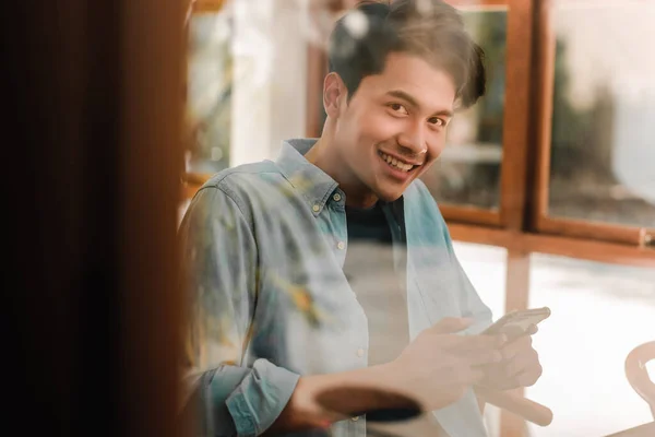 Jovem Feliz Sorrindo Olhando Para Câmera Através Janela Vidro Enquanto — Fotografia de Stock