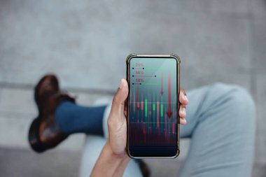 Mali ya da Ekonomik Kriz Konsepti. İş Lideri. Borsa Grafiği çöküyor ve düşüyor. Profesyonel İşadamı cep telefonunda Düşük Kâr grafiği görüyor