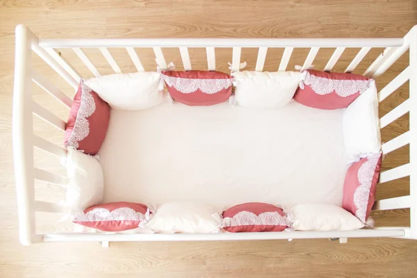 Cuna con almohadas de color blanco y borgoña con cordones — Foto de Stock
