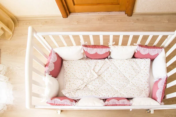 Baby bed crib with white and Burgundy color pillows with laces — Stock Photo, Image