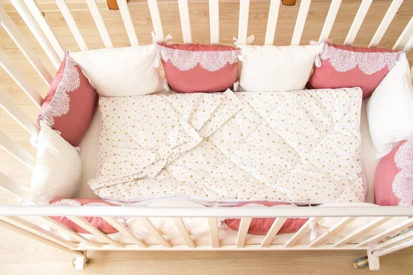 Baby bed crib with white and Burgundy color pillows with laces — Stock Photo, Image