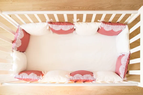 Baby bed crib with white and Burgundy color pillows with laces — Stock Photo, Image