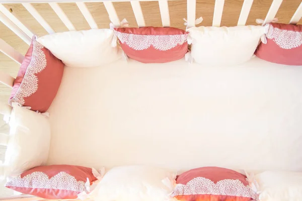 Baby bed crib with white and Burgundy color pillows with laces — Stock Photo, Image