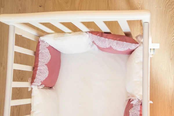 Baby bed crib with white and Burgundy color pillows with laces — Stock Photo, Image