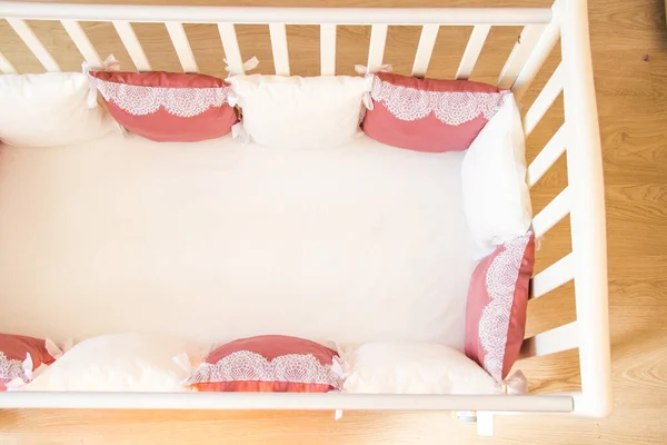 Baby bed crib with white and Burgundy color pillows with laces — Stock Photo, Image