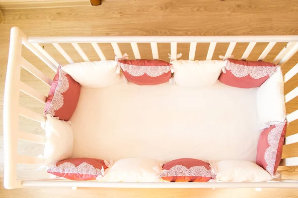 Baby bed crib with white and Burgundy color pillows with laces — Stock Photo, Image