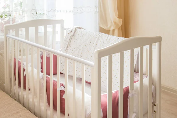 Berço de cama de bebê com almofadas de cor branca e borgonha com atacadores — Fotografia de Stock