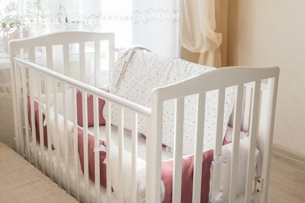 Berço de cama de bebê com almofadas de cor branca e borgonha com atacadores — Fotografia de Stock