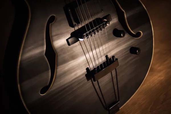 Guitarra de jazz negro con agujeros. acústica o semiacústica de cuerda hueca de acero —  Fotos de Stock