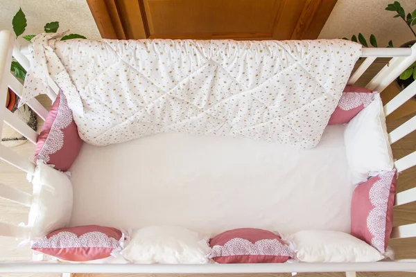Cuna con almohadas de color blanco y borgoña con cordones — Foto de Stock