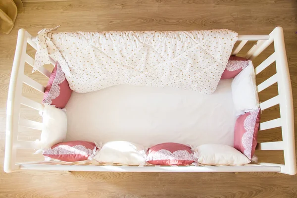 Berço de cama de bebê com almofadas de cor branca e borgonha com atacadores — Fotografia de Stock