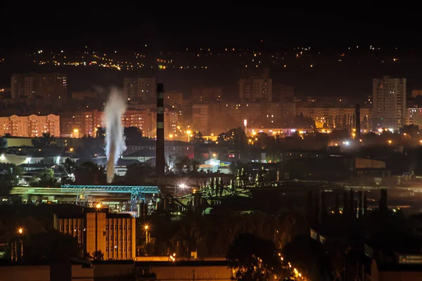 Nacht stad industriële zone. Rook uit de pijpen van de productie. Residentiële aeria huizen — Stockfoto