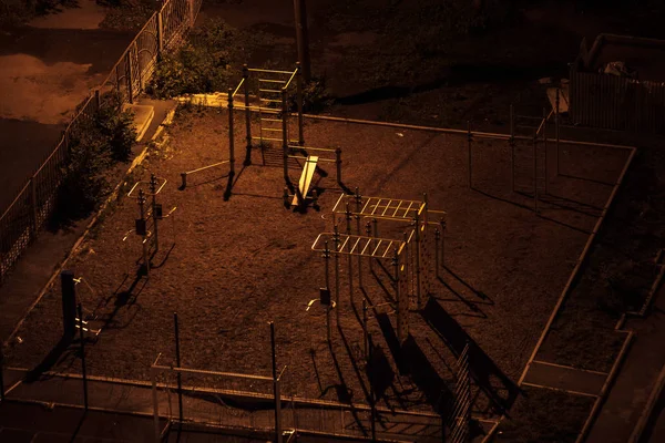 Luchtopname van een leeg sportveld 's nachts in een donkere tuin met lange schaduwen. Eén straatlamp — Stockfoto