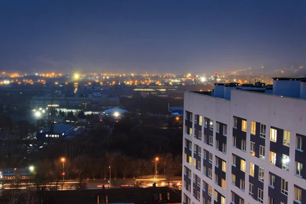 Avondzicht op een hoogbouw modern gebouw met flikkerende raamverlichting. — Stockfoto