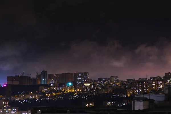 Plano de la noche de una ciudad en los edificios de la colina. Vista panorámica aérea superior — Foto de Stock