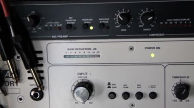 A rack of audio compressors and other components of sound reinforcement system in a recording studio close up. Signal and sound level indicators are flickering.Making music in the professional studio