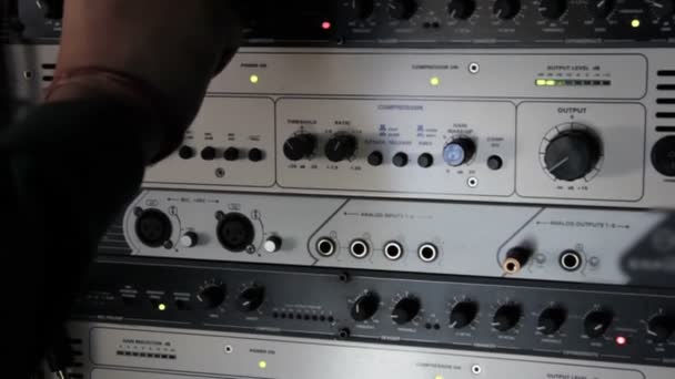 录音室中的一组音频压缩机和声音增强器的其他部件的机架 音响工程师用旋钮调整音标 在专业的录音室里做音乐 — 图库视频影像